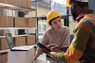 diverse stockroom team checking online orders tablet